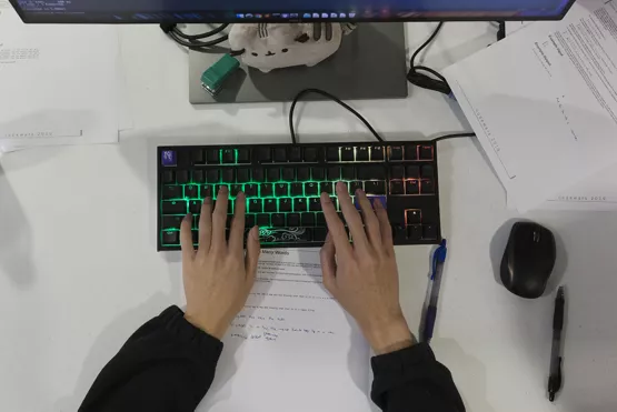 Student teams collaborate to solve coding challenges, reading problems aloud and working through solutions, with one member at the keyboard.