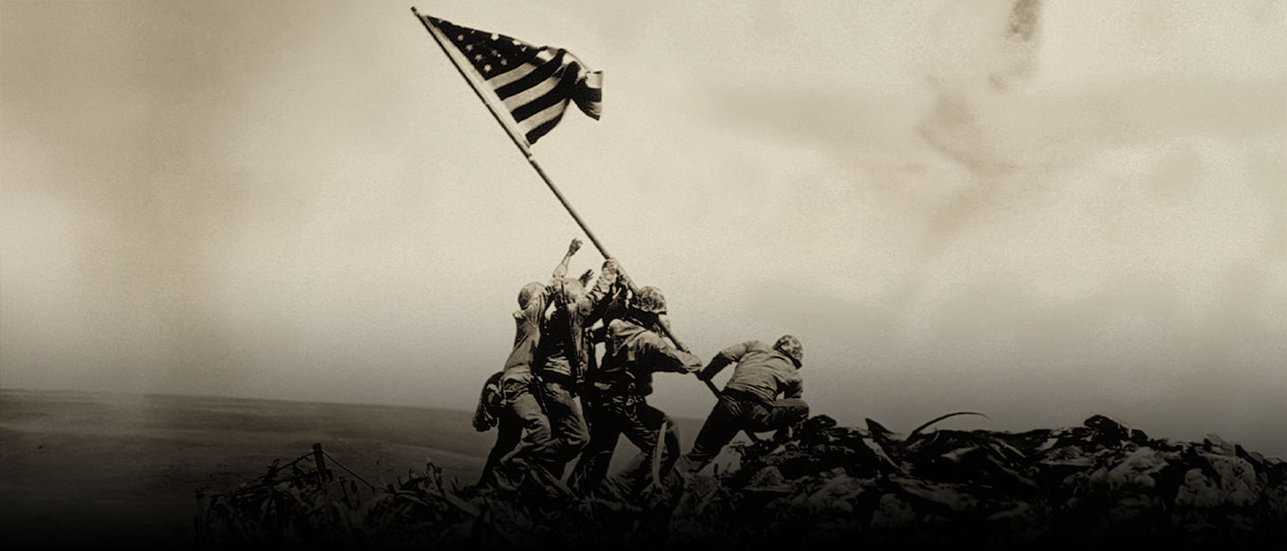 Historic photo of Marines raising American flag atop Mount Suribachi during Battle of Iwo Jima in 1945.