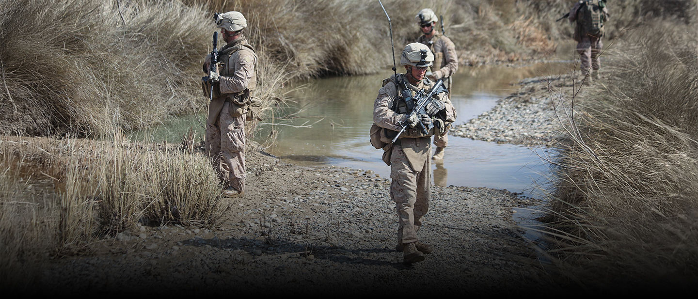 Infantry Marines patrol along a stream in Afghanistan following the September 11 attacks.