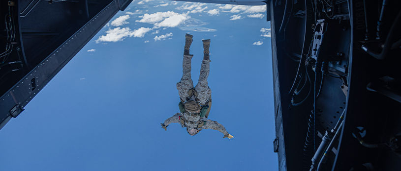 Marine jumping from aircraft during airborne operations training.