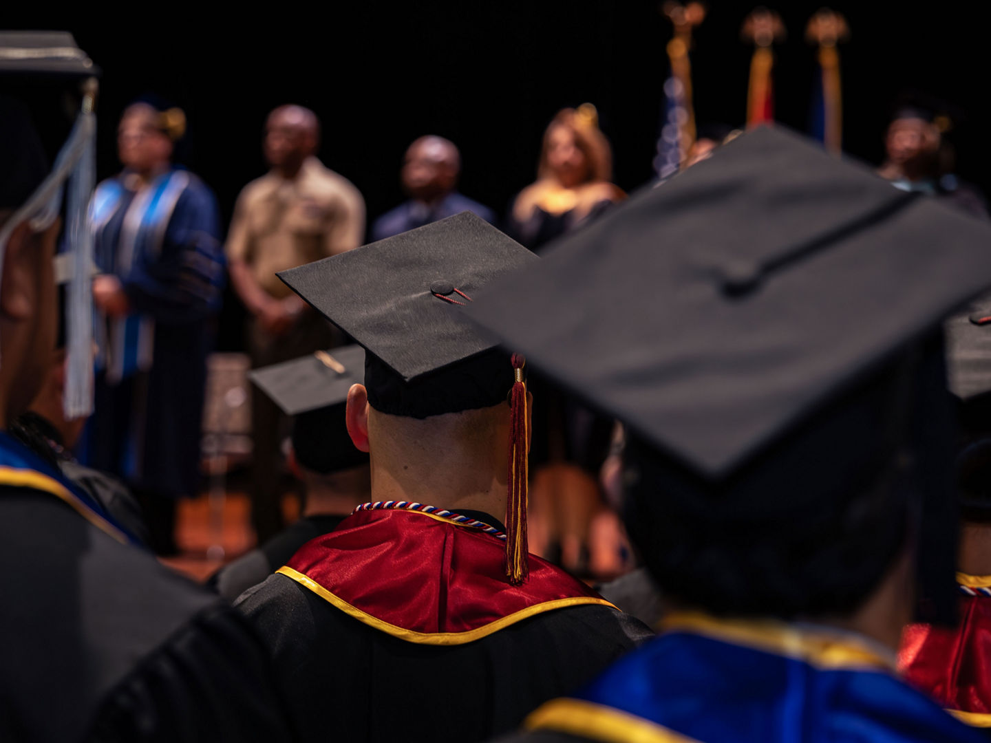 Marines in graduation caps and gowns during college commencement ceremony.
