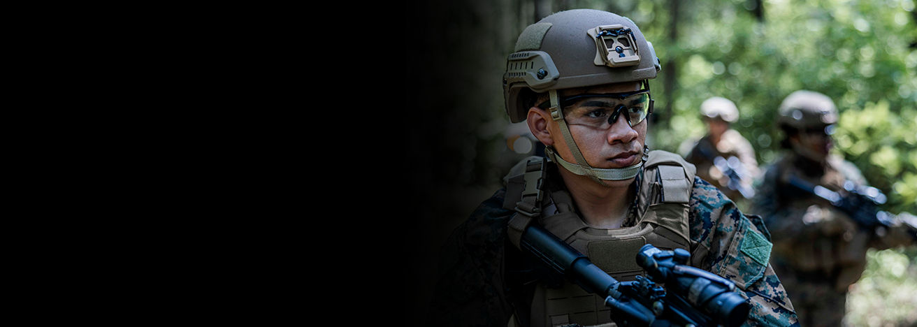 Marine in combat gear and helmet demonstrating tactical roles and specialties within Marine Corps ranks.