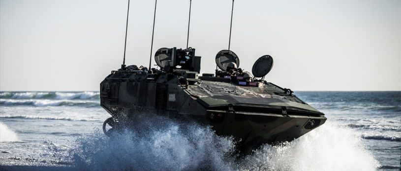 Marine ACV amphibious combat vehicle emerging from ocean surf demonstrating sea-to-shore assault capability.