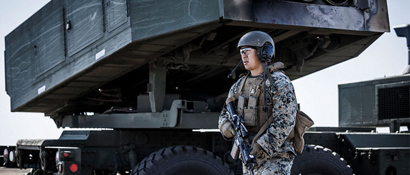 Marine operating HIMARS rocket artillery system demonstrating precision strike capability for future warfare.