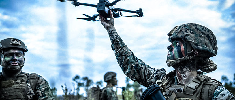 Marine launching tactical drone during field operations, demonstrating unmanned systems integration in warfare.