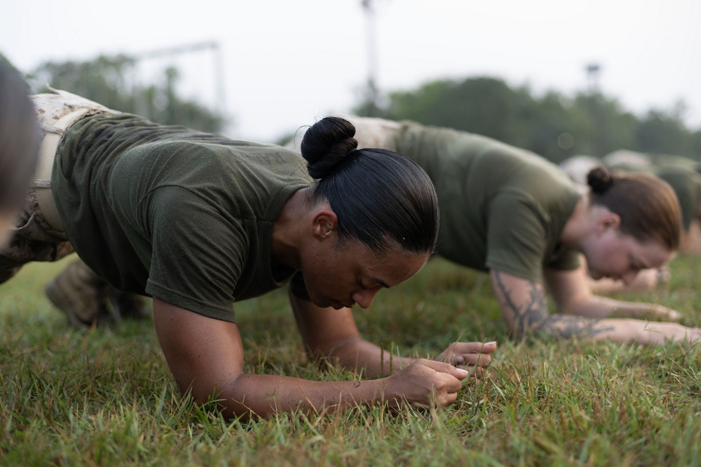 Female Marine recruits complete a plank pose. Plank poses are a tested exercise during both the IST and PFT. 