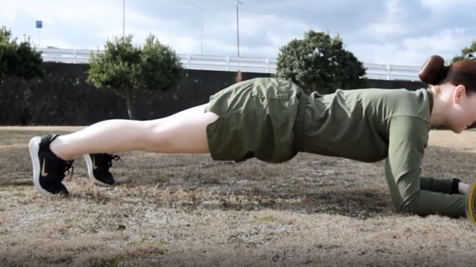 Young Caucasian Male in Sportswear Doing Push Ups on a Green