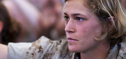 Marine raising her hand in a classroom.