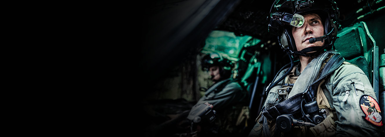 Marine aviator in flight helmet and gear piloting aircraft during mission operations.