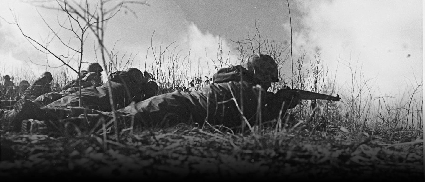 Historical photo of Marines in defensive positions during Battle of Chosin Reservoir in freezing conditions during Korean War 1950.