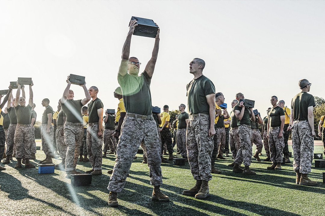 Marine recruits performing overhead ammo can lifts during Combat Fitness Test physical fitness assessment.