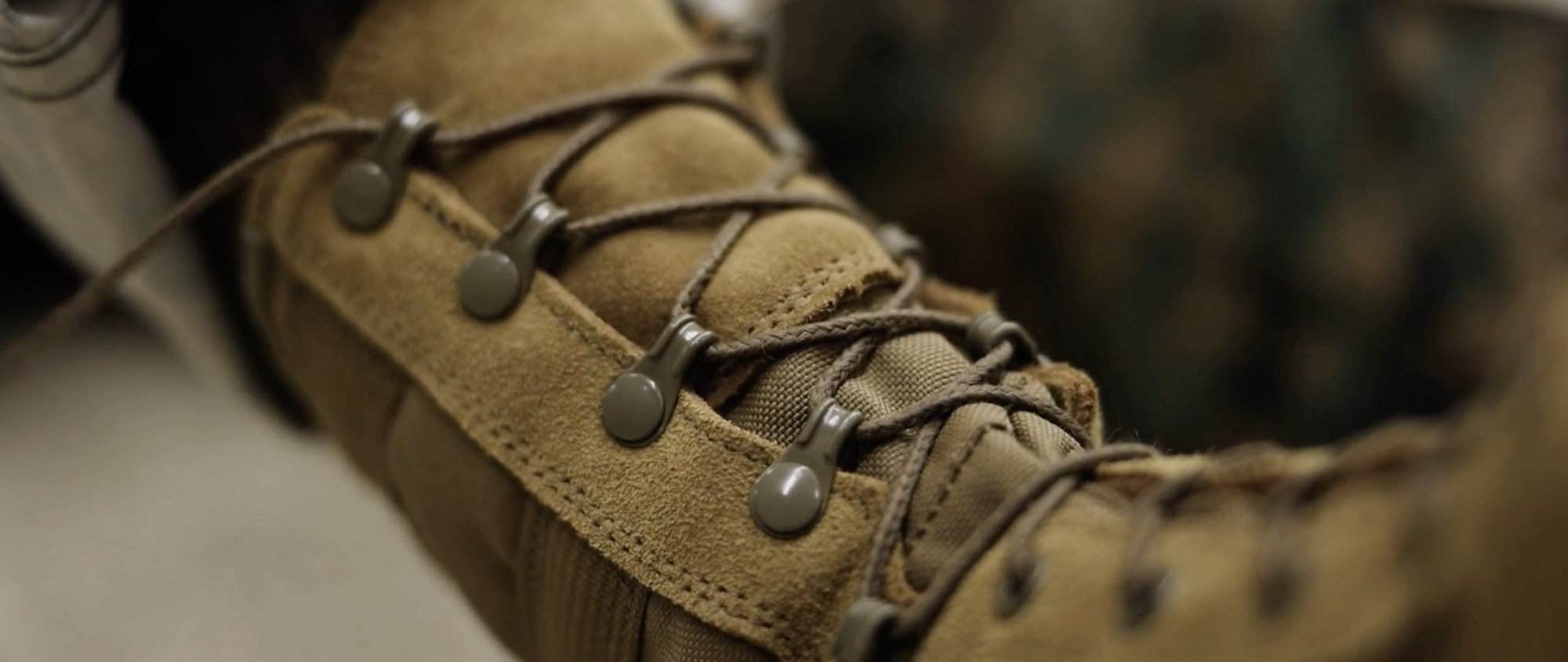Marines in camouflage uniforms and boots, marching.