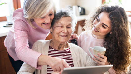 Three women looking at a tablet together.