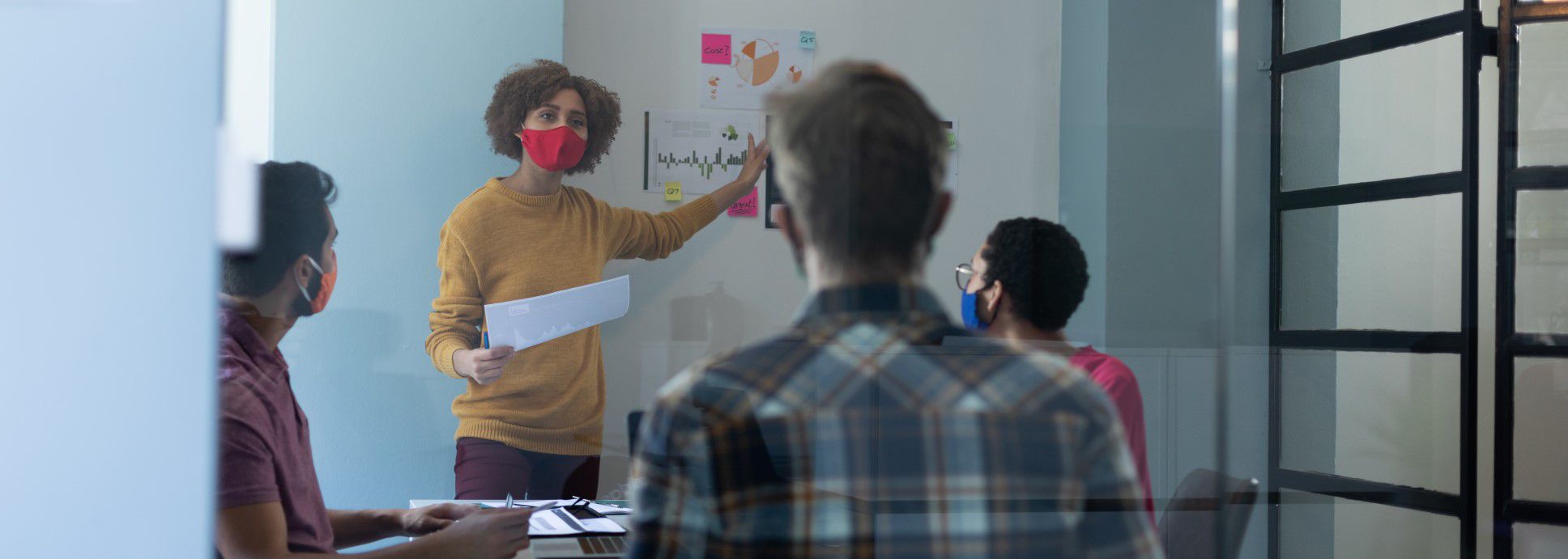 Workers at an office meeting with masks on