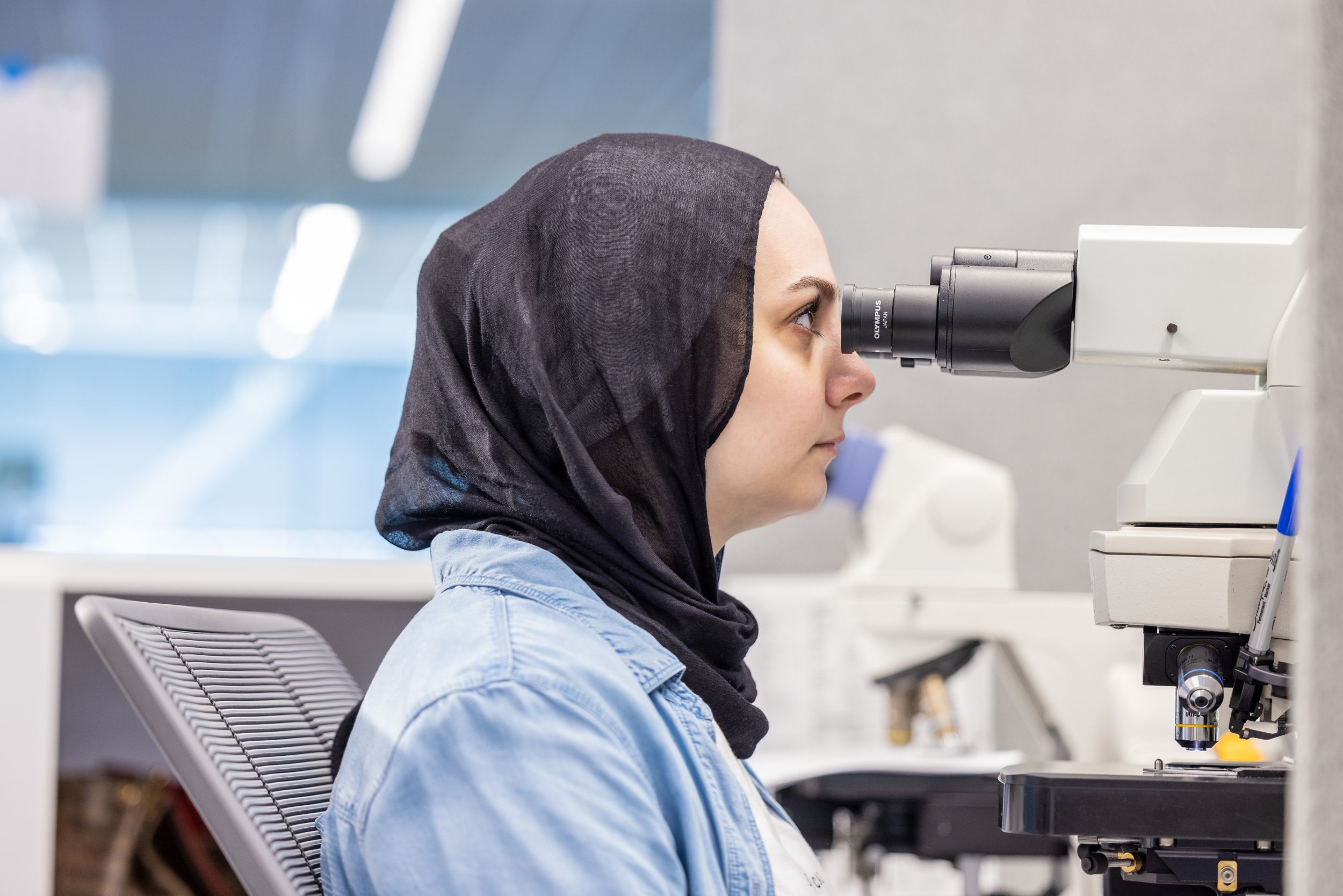 Lab worker using a microscope for pathology purposes