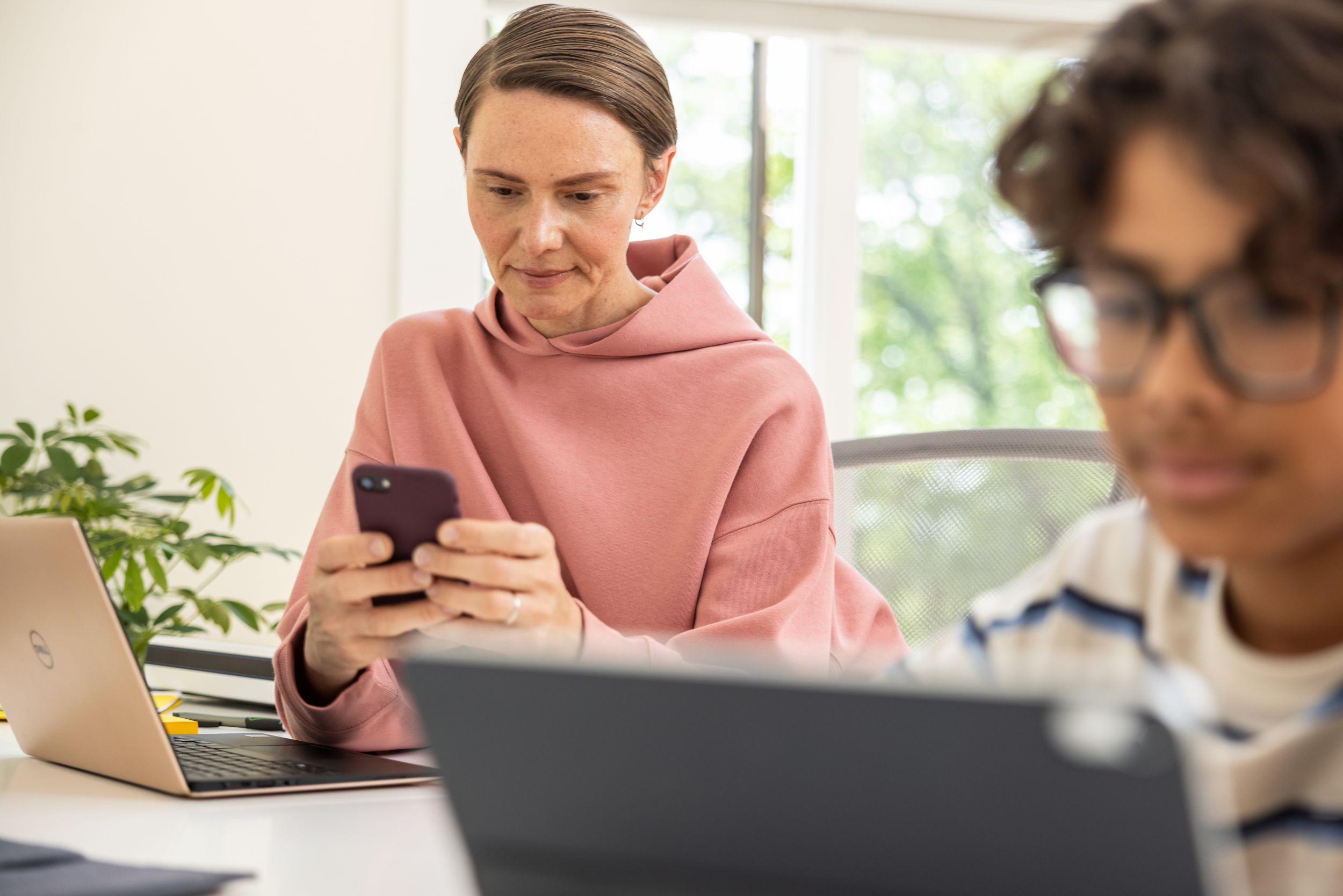 woman sitting and looking at her handheld device