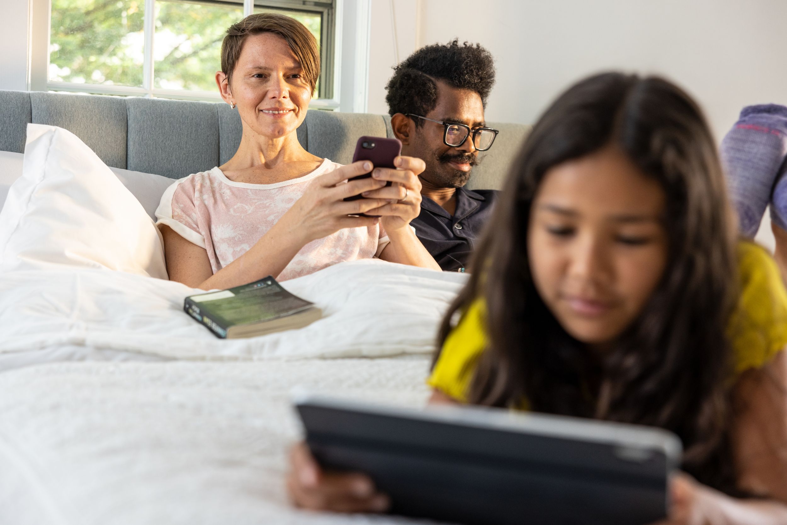 Mother and father sitting in bed with child