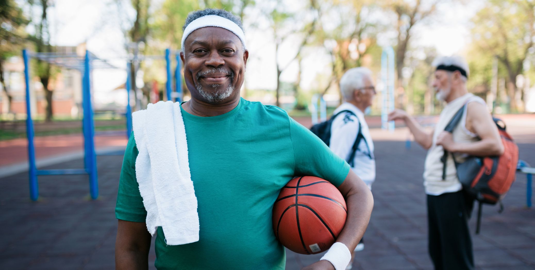 Man standing at basketball court holding basketball