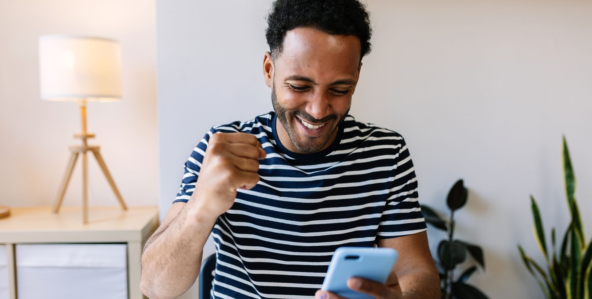 Man looking at cell phone cheering