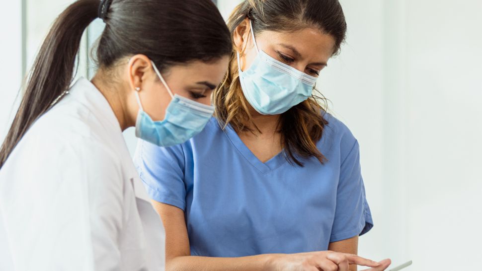 An image of two healthcare professionals looking at a tablet together.