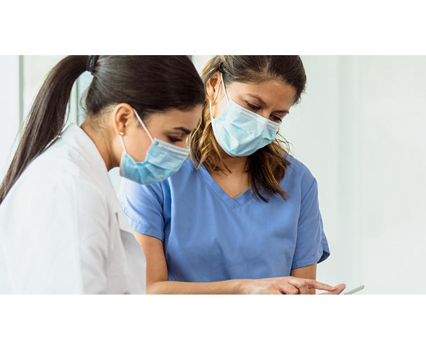 An image of two healthcare professionals looking at a tablet together.