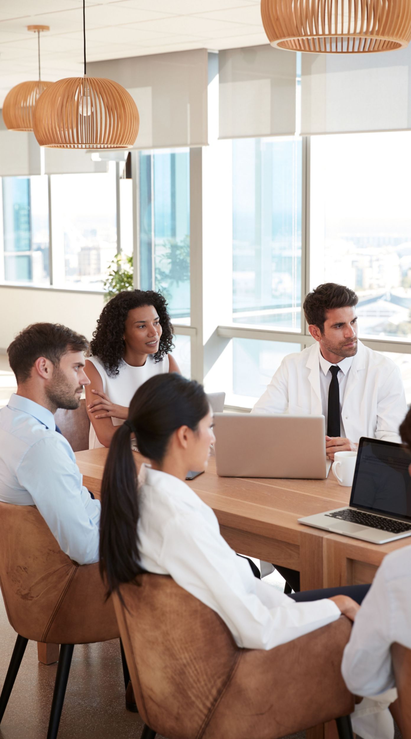 Group Of Medical Staff Meeting Around Table In Hospital