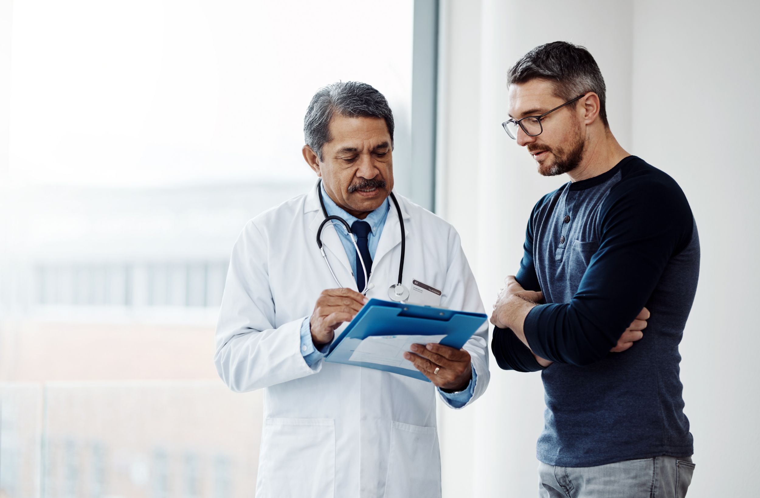 Shot of a confident mature male doctor consulting a patient  inside a hospital