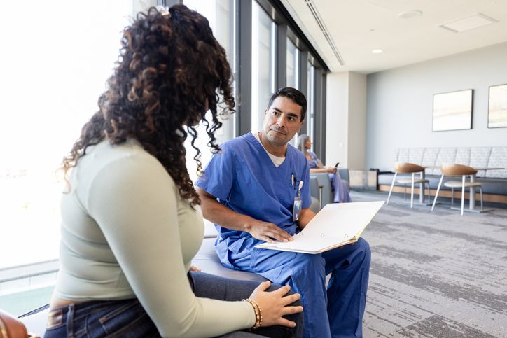 While her son is having a procedure, the mother answers questions with the nurse in the lobby.