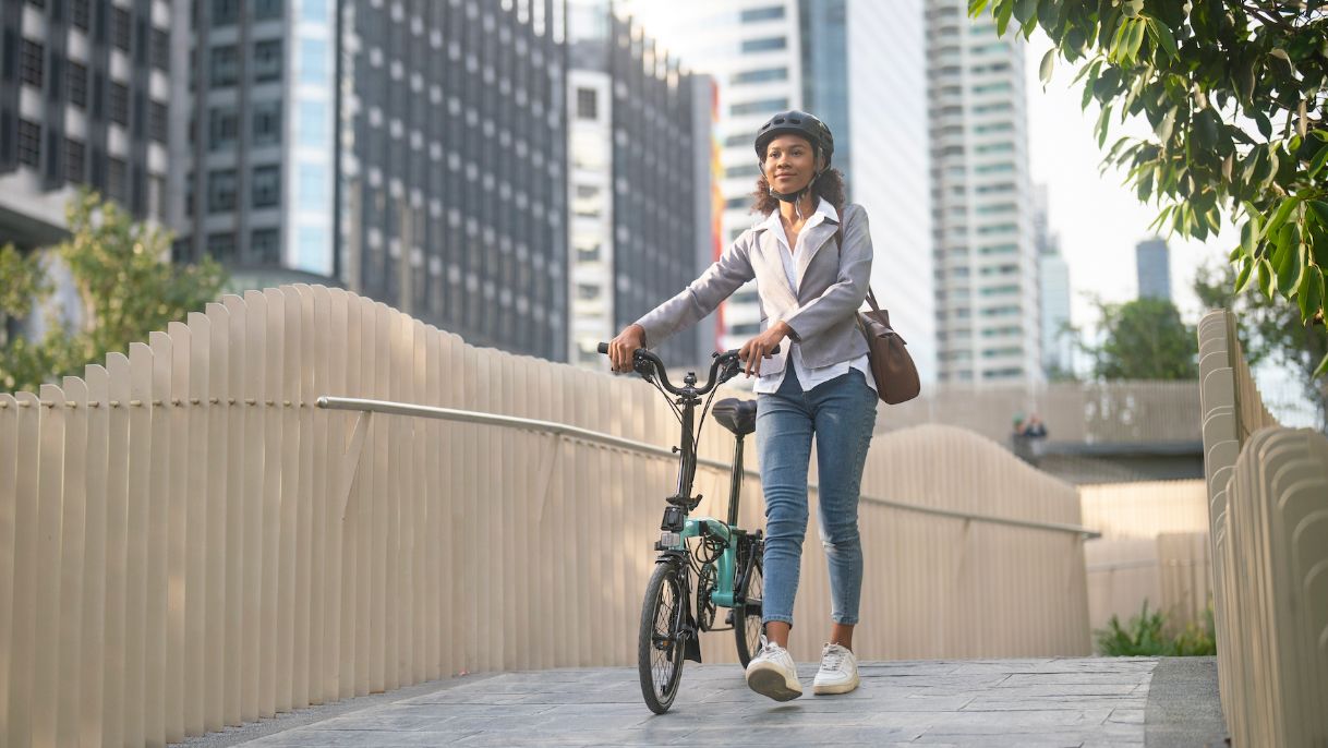 A woman standing and holding her bike