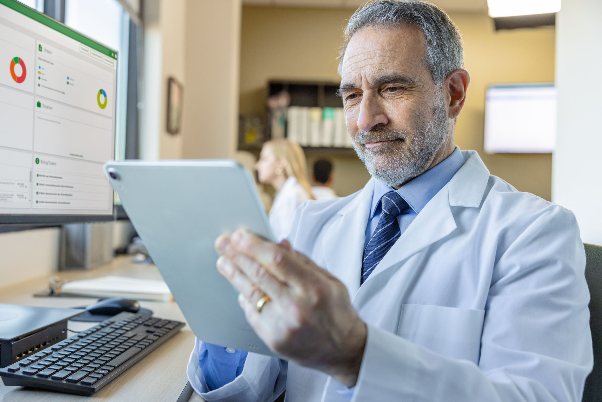 Male physician working on a tablet while in a medical office.