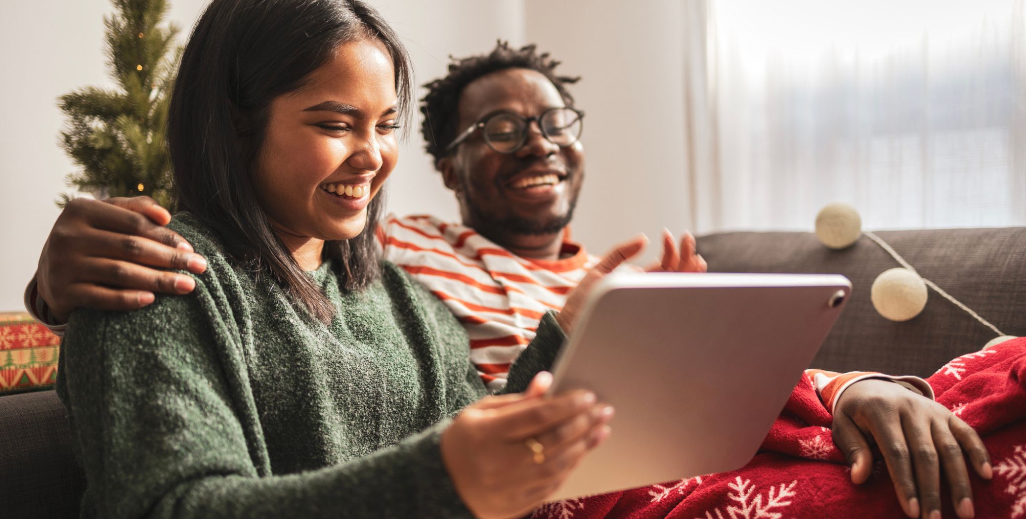Couple on couch looking at an ipad