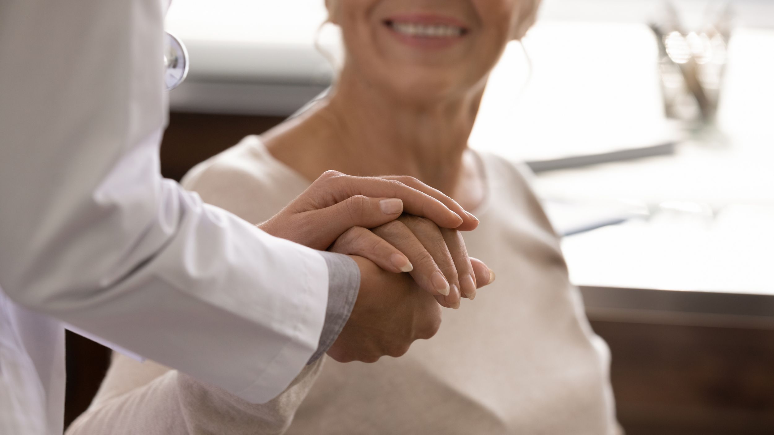 supportive female nurse comfort caress touch hold mature patient hand. Woman doctor support take care of senior client at consultation, show empathy and love. Healthcare concept.