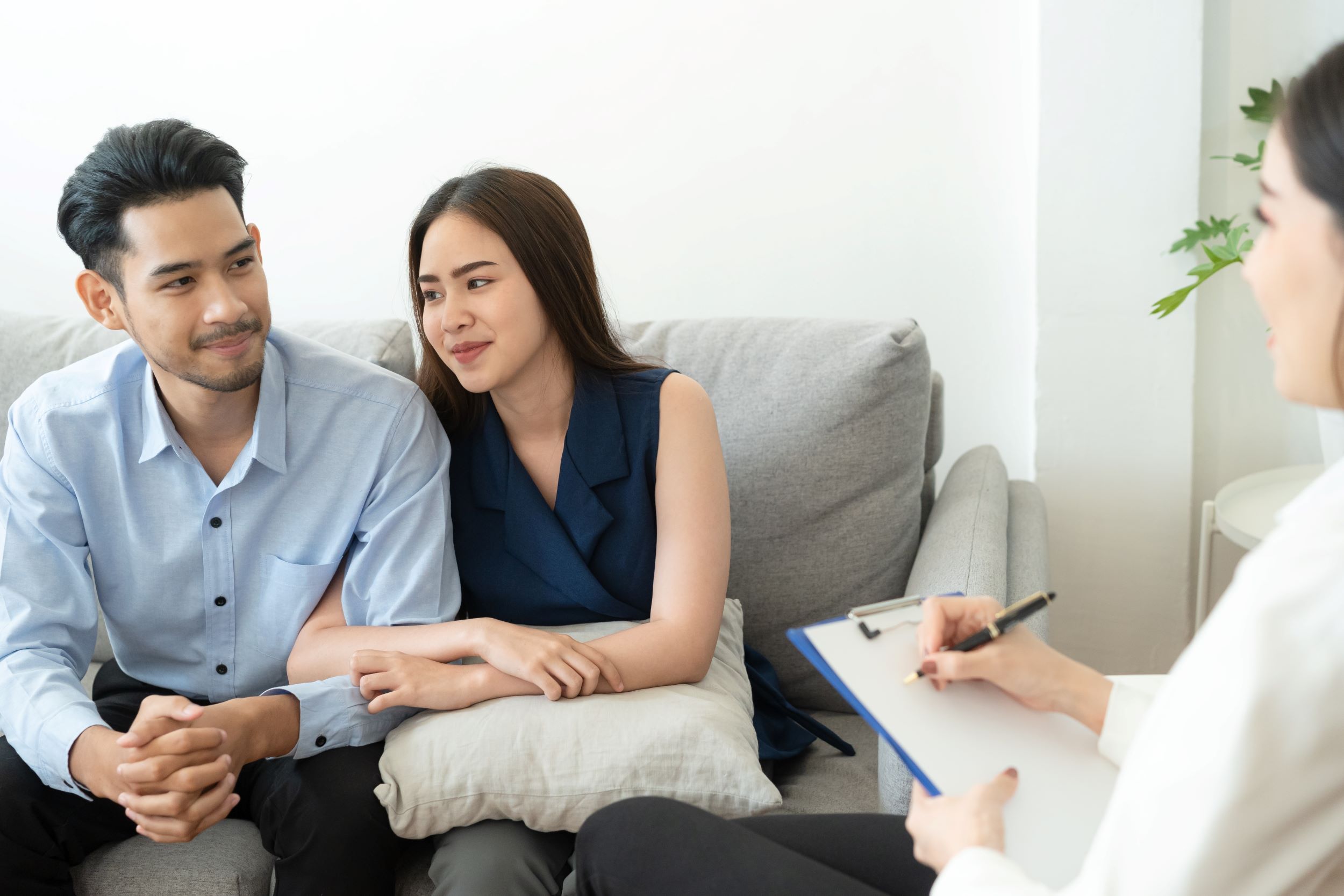 Couple seated on couch across from healthcare professional having discussion