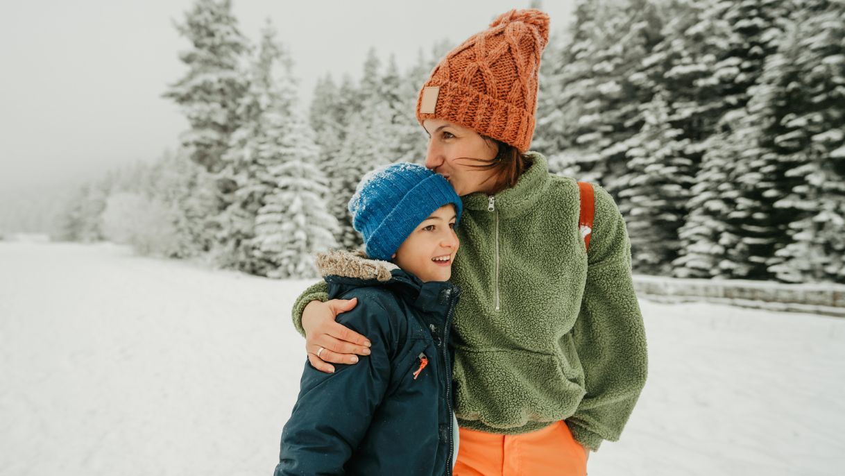 Mom hugging boy in snow