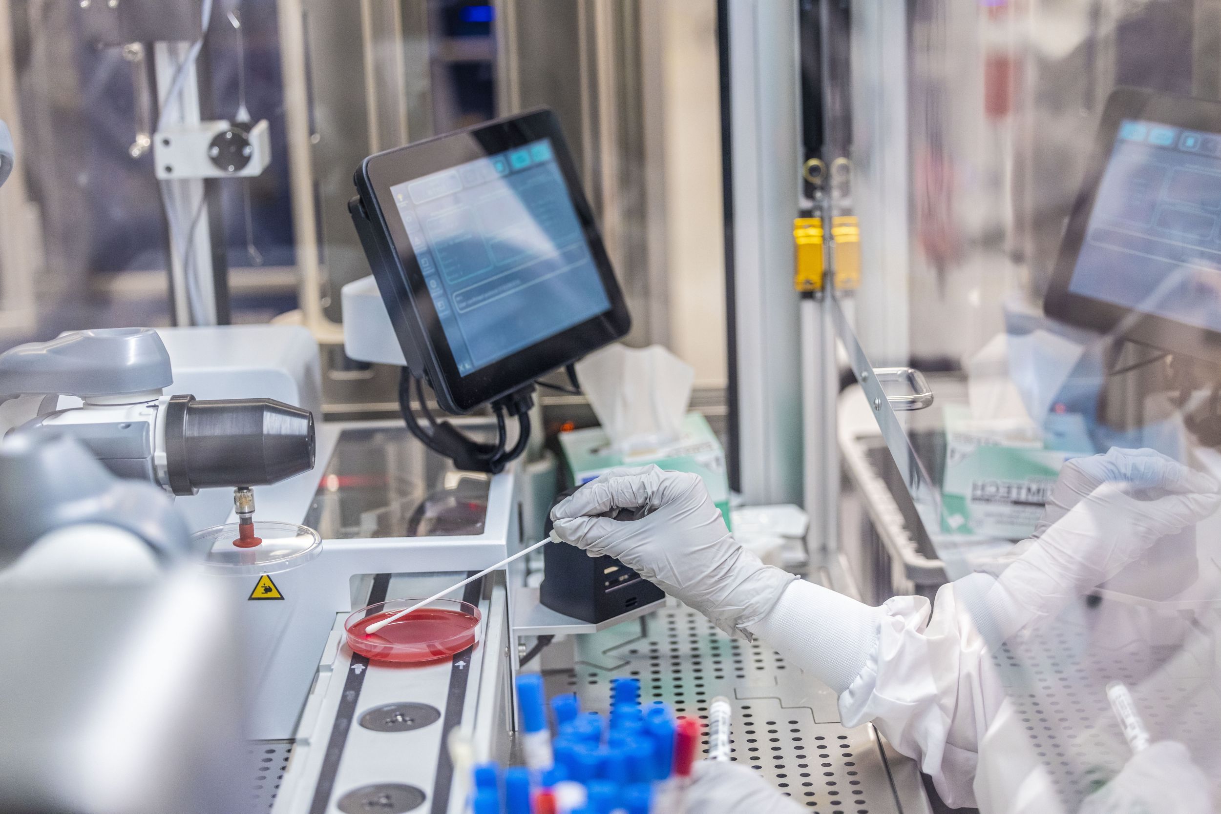 A hand testing a sample in a lab