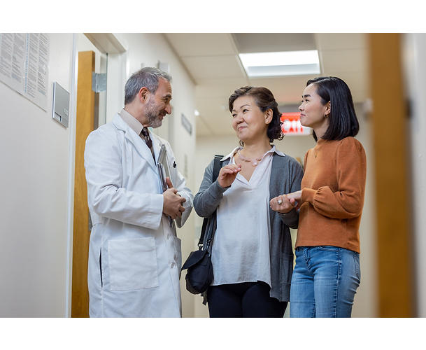 An image of a doctor speaking with two patients. 