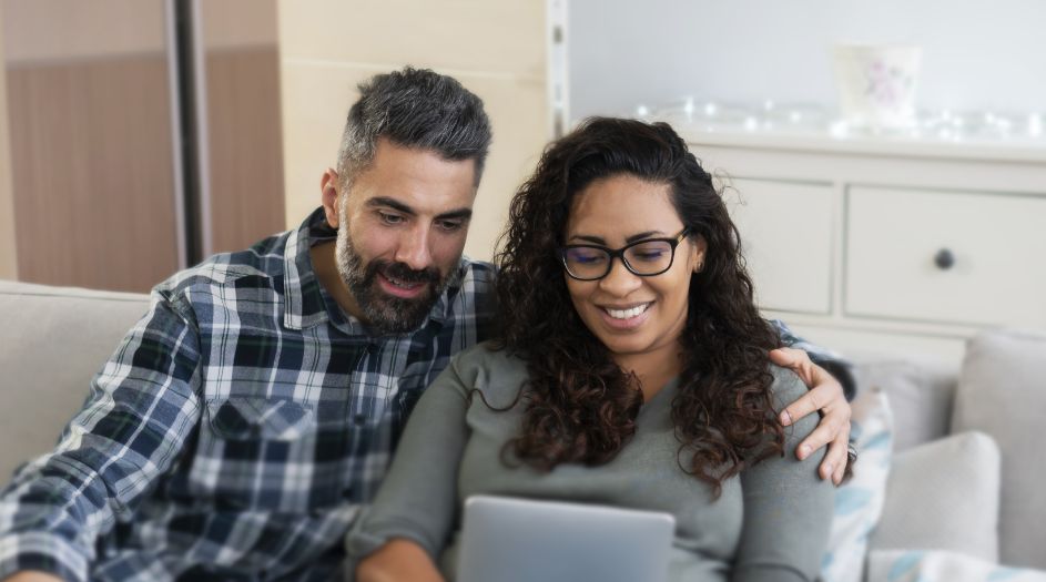 couple on couch looking at tablet