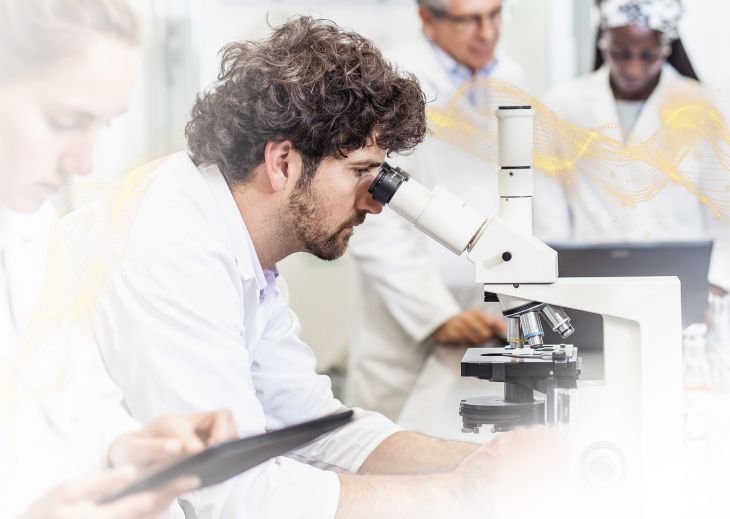 lab tech looking through microscope