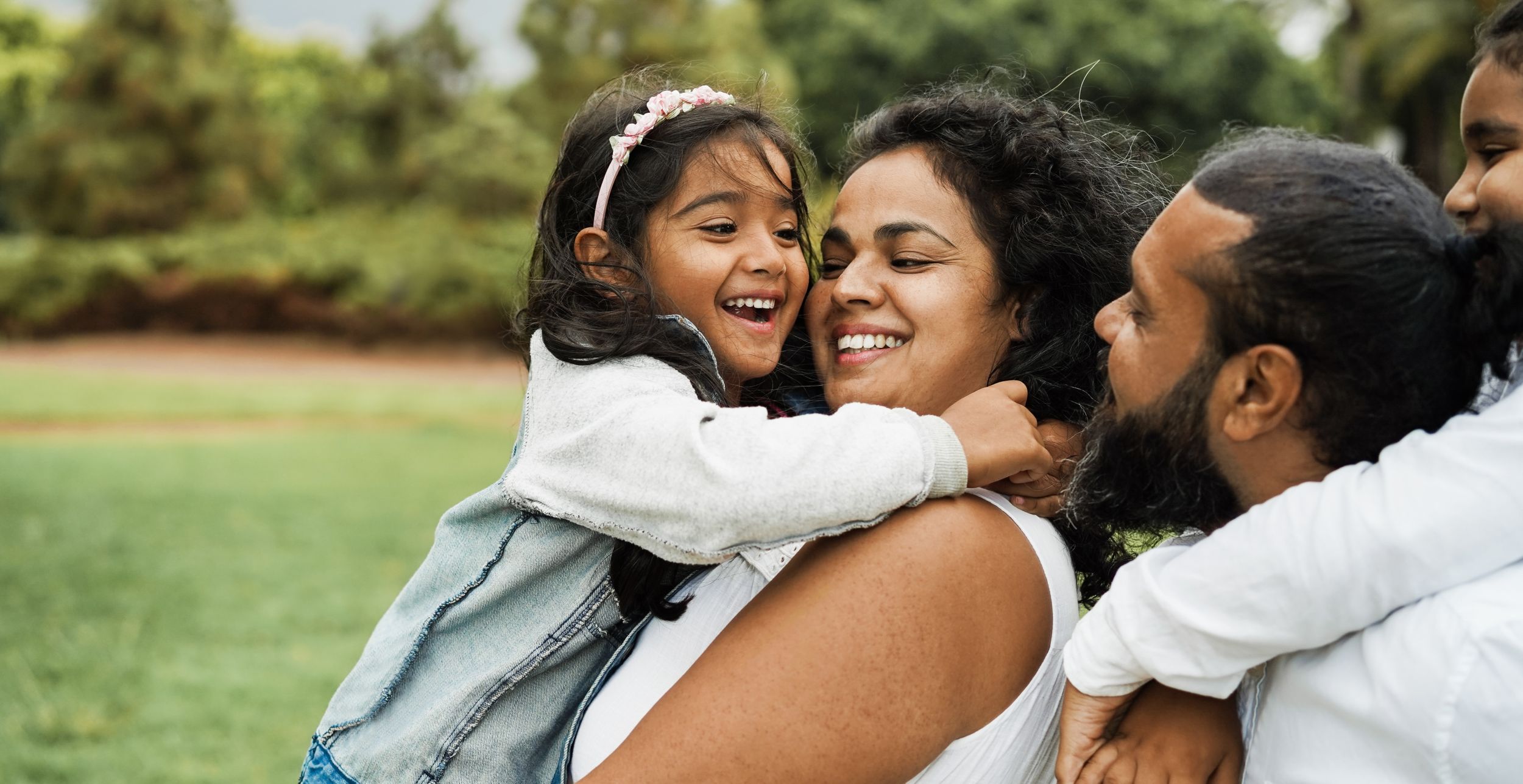 Happy indian family having fun outdoor - Hindu parents laughing with their children at city park - Love concept - Main focus on mother and daughter face