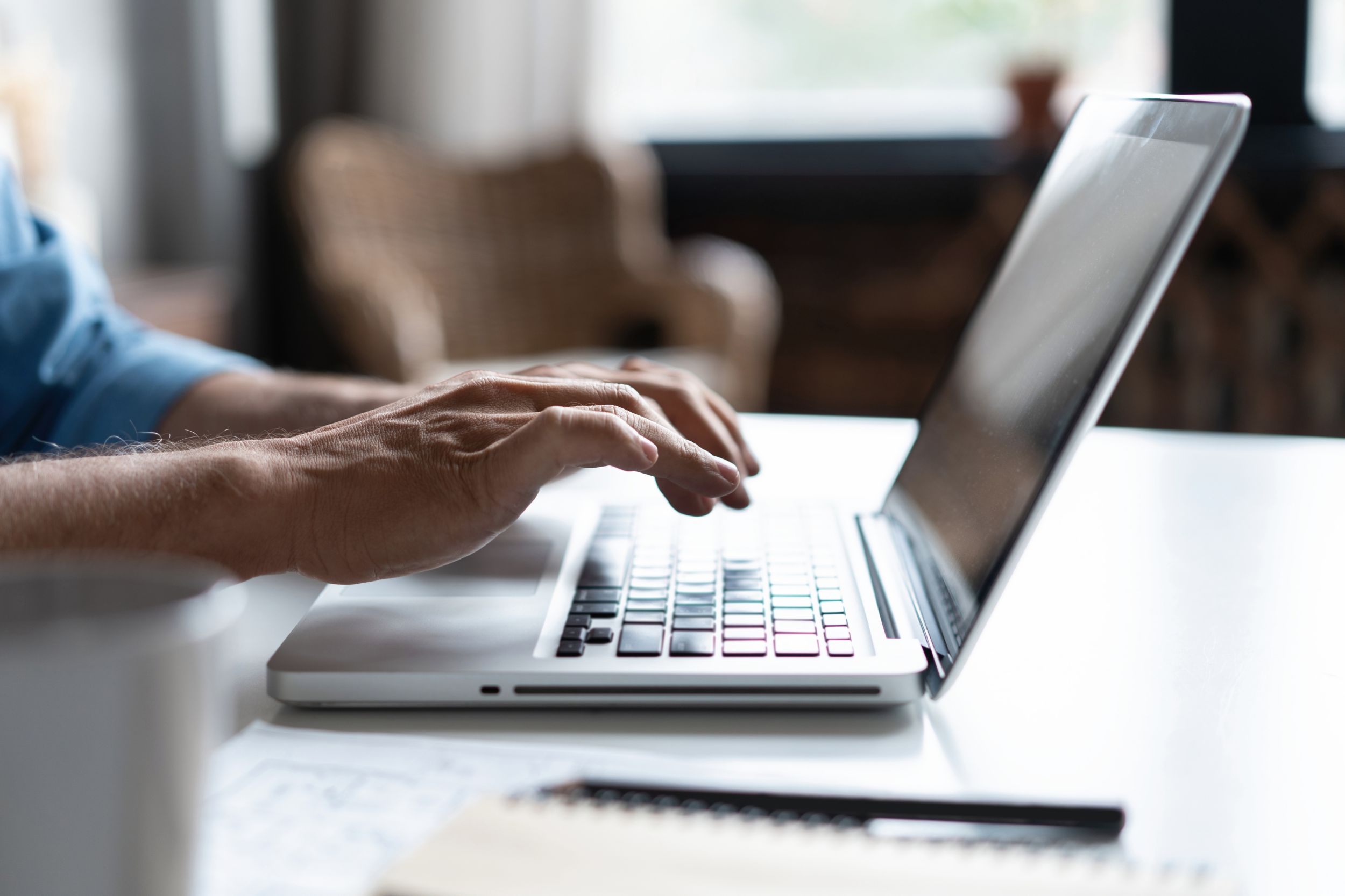 Close up of man's hands typing on laptop