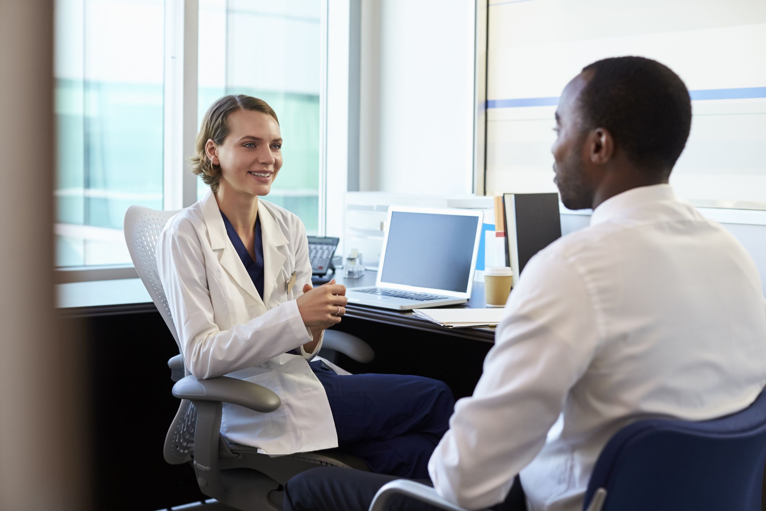 Doctor In Consultation With Male Patient In Office