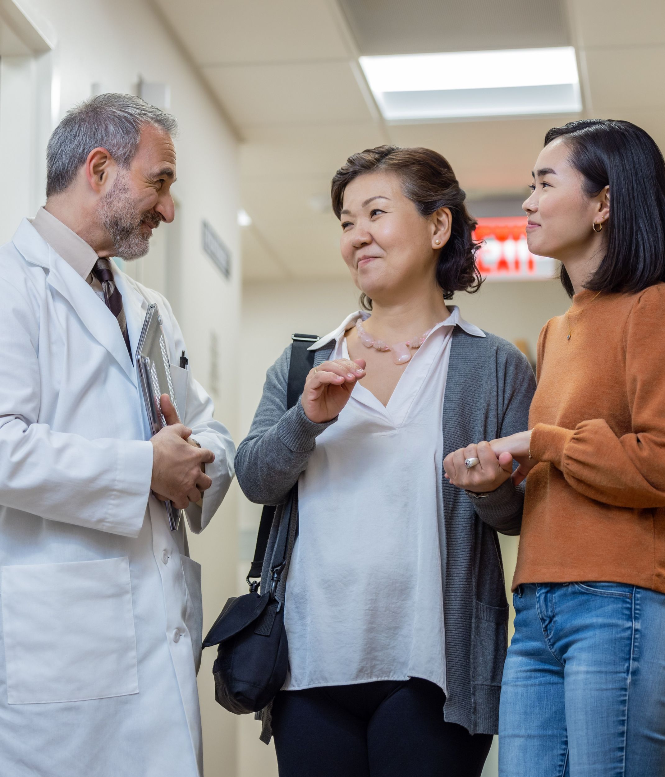 Healthcare provider engaged in conversation with two female patients