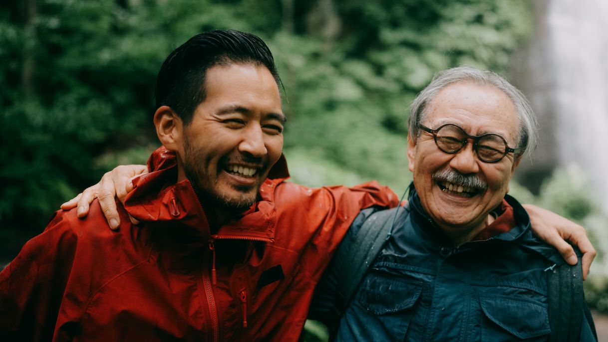 Two men with arms wrapped around each others shoulders