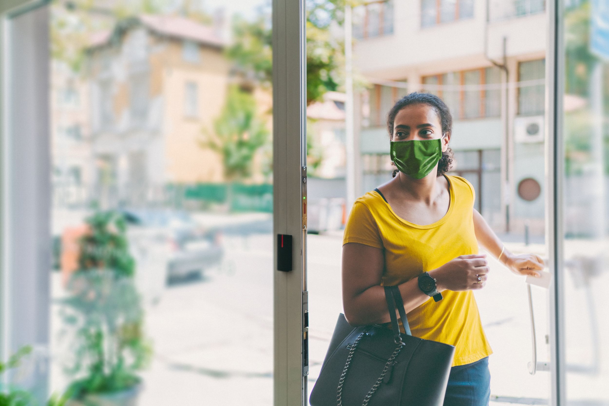Woman with mask walking into a Quest patient service center.